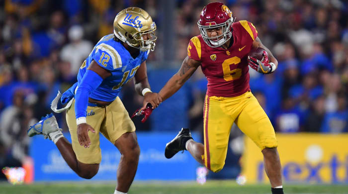 Southern California Trojans running back Austin Jones runs the ball against UCLA Bruins defensive lineman Grayson Murphy.